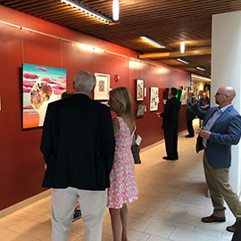 Visitors of the opening reception take in the exhibition.